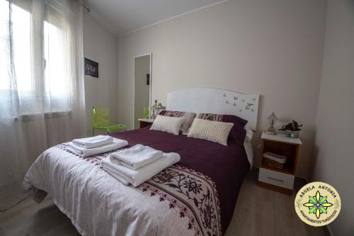 1 dormitorio con 1 cama con toallas en AT la Abuela Antonia-La Casina, en Torre de Don Miguel