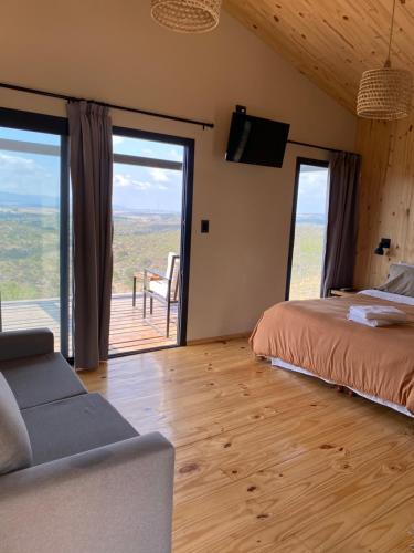 a bedroom with a bed and a couch and a balcony at Finca Granero in Potrero de Garay