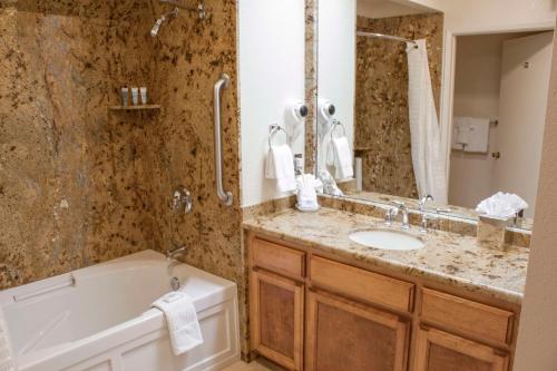 een badkamer met een bad, een wastafel en een bad bij Hilton Vacation Club San Luis Bay Avila Beach in Avila Beach