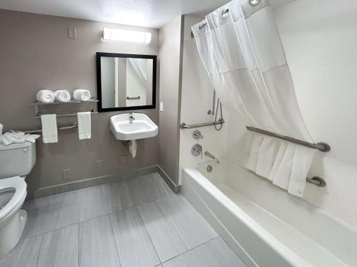 y baño con bañera, lavabo y aseo. en Studio 6 Suites Cameron Park, CA Folsom, en Cameron Park