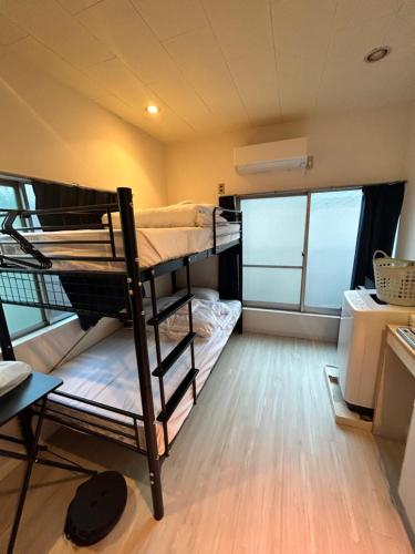 um pequeno quarto com dois beliches em Meguro Apartment em Tóquio