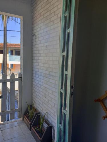 an open door to a balcony with plants on it at Chalés Caiçara Serrambi in Porto De Galinhas