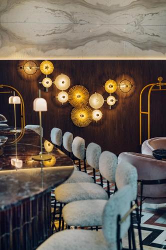 a row of chairs lined up against a wall with lights at Hotel Pinar Plaza in Madrid