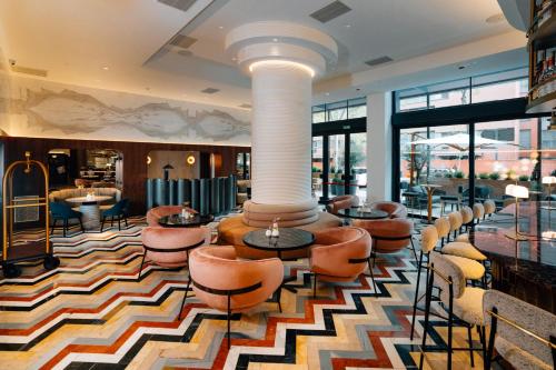 a lobby with chairs and tables in a hotel at Hotel Pinar Plaza in Madrid
