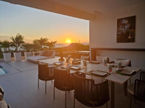 a dining room with a table and a view of the sunset at Villa Regatta in Hato
