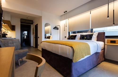 a bedroom with a large bed and a kitchen at Opal Executive Suites in Nafplio