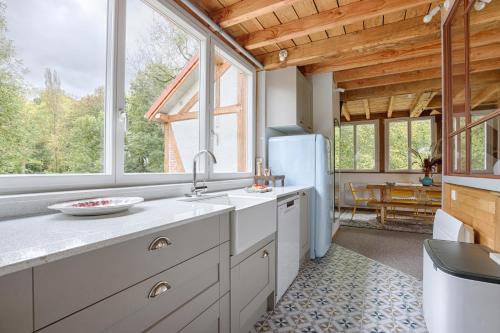 a kitchen with a sink and a refrigerator at La Rivière 10 mn DisneylandParis in Chalifert