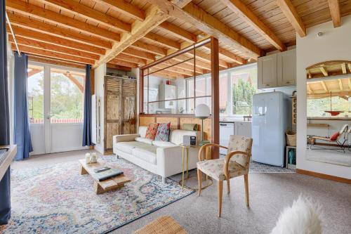 a living room with a white couch and a kitchen at La Rivière 10 mn DisneylandParis in Chalifert