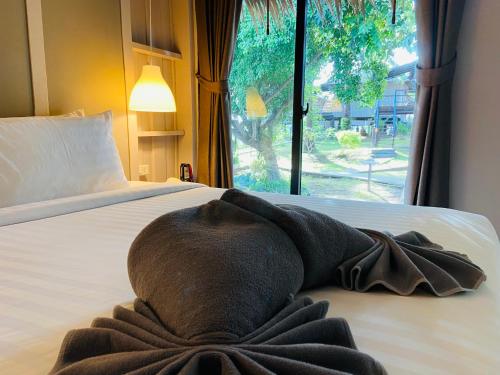 a towel laying on a bed with a window at HIP Seaview Resort @ Phi Phi in Phi Phi Don