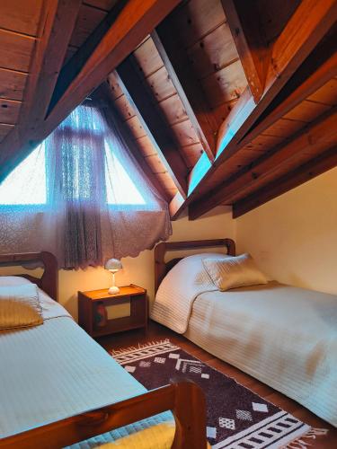 a attic room with two beds and a window at Barbati Sunrise Suite in Barbati