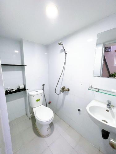 a white bathroom with a toilet and a sink at Lucky Hotel Apartment in Ho Chi Minh City