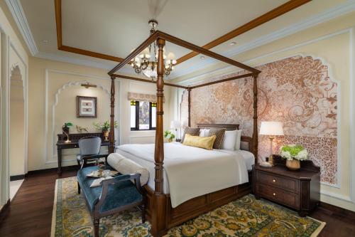 a bedroom with a canopy bed and a desk at Taj Usha Kiran Palace, Gwalior in Gwalior