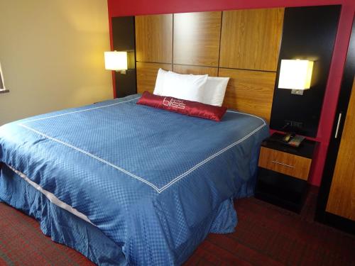 a bed in a hotel room with a red pillow on it at Hotel Bliss - Brooklyn in Brooklyn