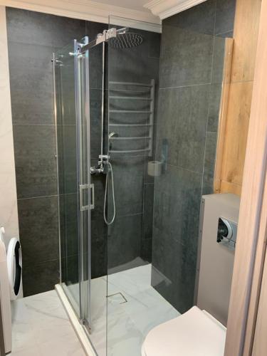 um chuveiro com uma porta de vidro na casa de banho em Riverside apartment self check-in em Klaipėda