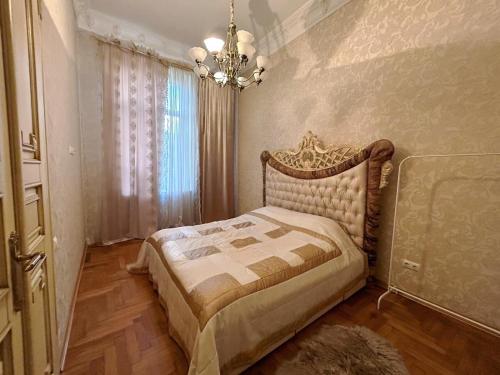 1 dormitorio con cama y lámpara de araña en GoldenApartmentLviv, en Leópolis
