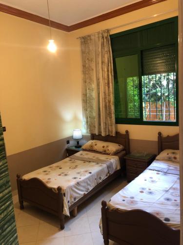 1 Schlafzimmer mit 2 Betten und einem Fenster in der Unterkunft Typique Appartement-Villa in Al Hoceïma