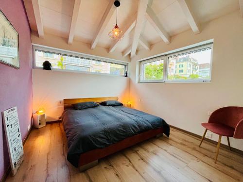 納沙泰爾的住宿－A La Côte，一间卧室设有一张床和两个窗户。