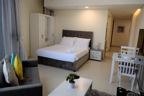 een slaapkamer met een bed en een woonkamer bij EasyGo - Al Multaqa Mirdif Hills Studio in Dubai