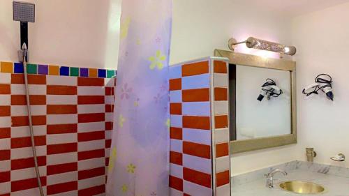 a bathroom with a shower with a sink and a mirror at Les Jardins Yasmina Bin el-Ouidane in Bine el Ouidane