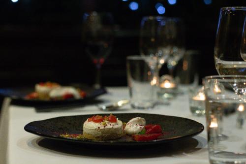 a plate of food on a table with wine glasses at Hotel du Lac in Villars-sur-Ollon
