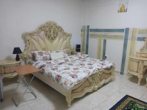 a bedroom with a large bed with a large headboard at nice room inside an apartment in Abu Dhabi