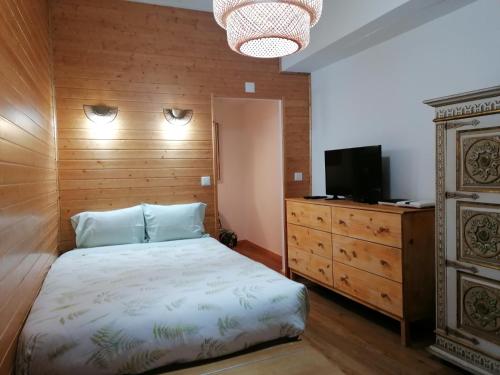 a bedroom with a bed and a television and a dresser at Era Uma Vez Apartment in Vila Real