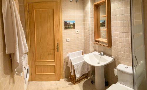 a white bathroom with a sink and a toilet at Casa Chuanina in Benasque