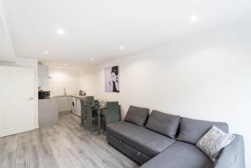 a living room with a couch and a kitchen at Glasgow City, Hydro Apartment in Glasgow