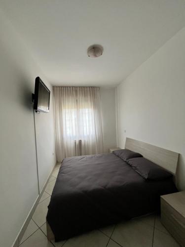 1 dormitorio con 1 cama grande y TV en Sottomarina Beach apartment, en Chioggia