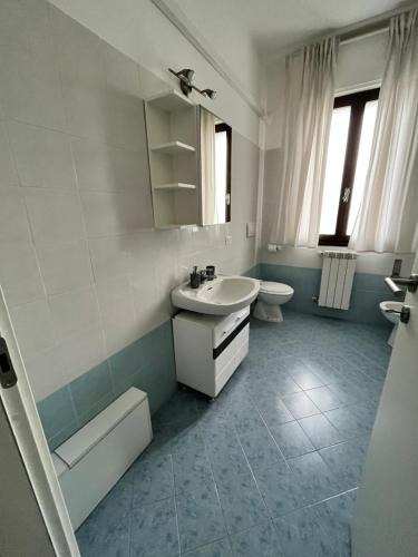 y baño con lavabo, aseo y espejo. en Sottomarina Beach apartment, en Chioggia