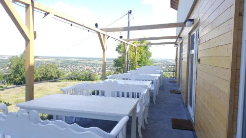 a row of white tables on a balcony at Levendulászat in Simontornya
