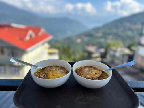 two bowls of food on a tray with a view at DISHA SILVER PEAK Hotel in Pelling
