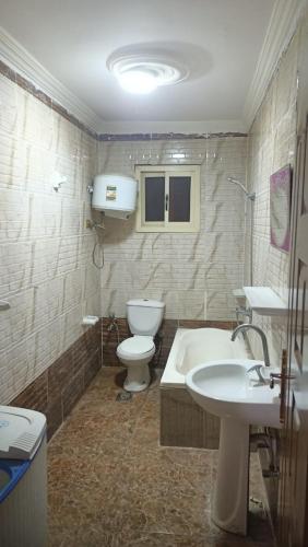 uma casa de banho com um WC, uma banheira e um lavatório. em مفروش مصر الجديده no Cairo