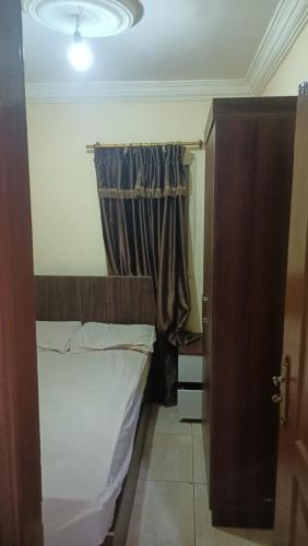 um pequeno quarto com uma cama e uma janela em مفروش مصر الجديده no Cairo
