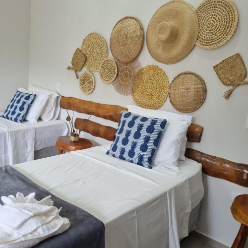 a room with two beds and hats on the wall at Pousada La Vita in São Miguel dos Milagres