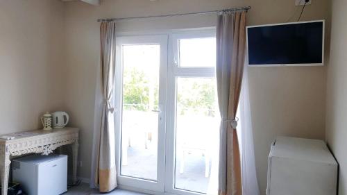 a room with a sliding glass door with a television at Levendulászat in Simontornya
