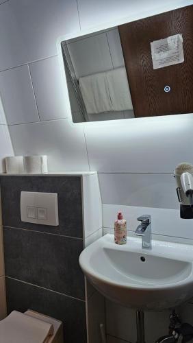 een badkamer met een wastafel en een spiegel bij Hotel Kölner Hof in Mülheim an der Ruhr
