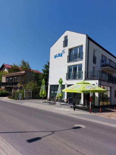 a building with an umbrella next to a street at Pensjonat Alka in Kołobrzeg