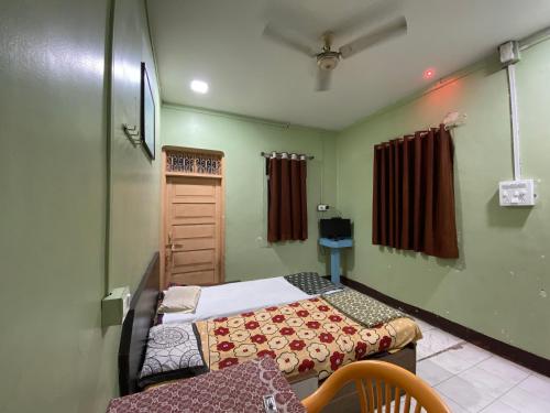 a small room with two beds and a window at MUKTAI LODGE in Solapur