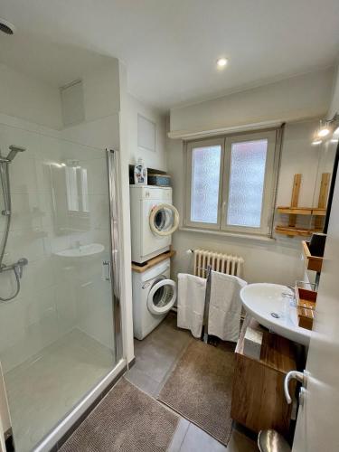 une salle de bain avec douche et lavabo et une machine à laver dans l'établissement Appartement Hyper Centre Place Kléber 66 m2, à Strasbourg