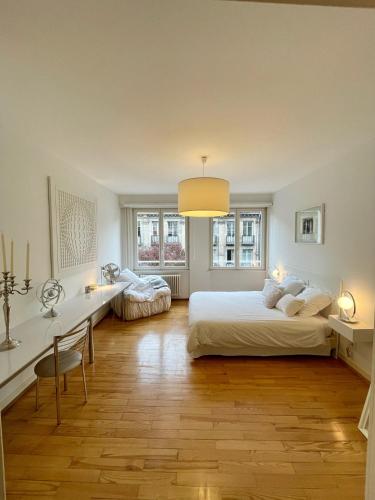 a white bedroom with two beds and a desk and a table at Appartement Hyper Centre Place Kléber in Strasbourg