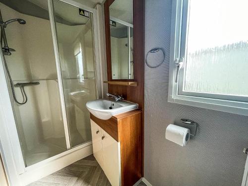 ein Bad mit einem Waschbecken und einer Dusche in der Unterkunft Modern Caravan With Wifi At Martello Beach Holiday Park In Essex Ref 29010kv in Clacton-on-Sea