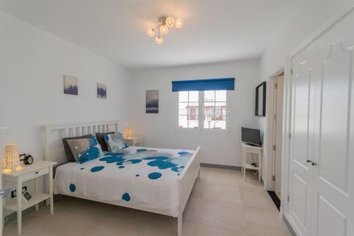 a white bedroom with a bed and a desk at Casa Rosanna in Playa Blanca
