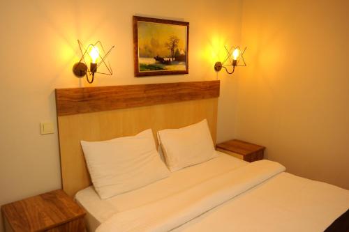 um quarto com uma cama branca e duas luzes na parede em Sheriff Residence em Istambul