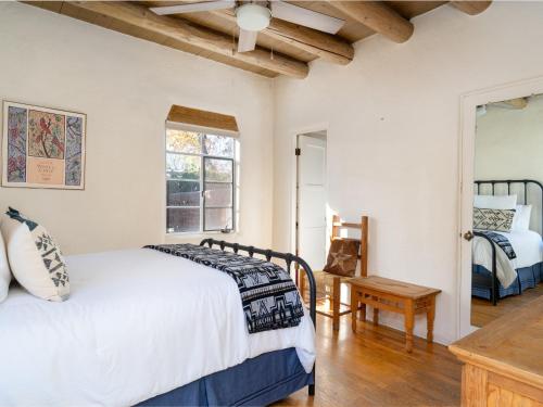 a bedroom with a bed and a table and a window at Casita Stieglitz in Santa Fe