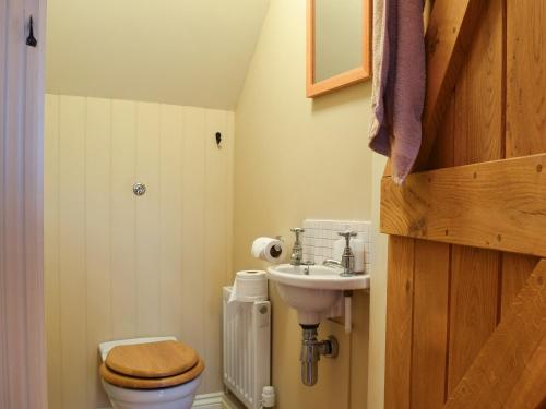 a small bathroom with a toilet and a sink at Bea Cottage in Bourton on the Water