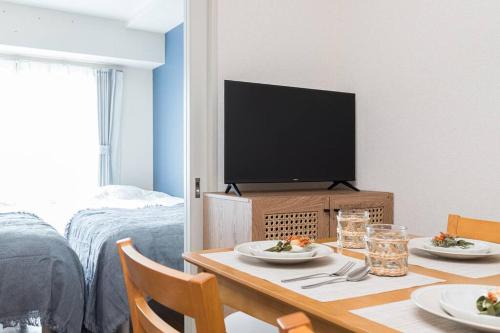 Apartment hotel Hana in Yokohama في يوكوهاما: غرفة مع طاولة مع طبقين من الطعام