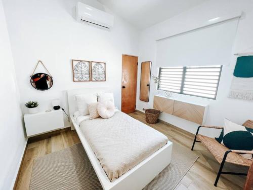 a white room with a bed and a chair at Boho Style House Super Comfortable For 5@ San Juan rey 2 apt 1 in San Juan