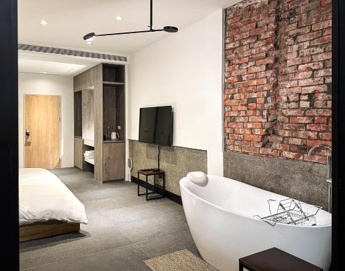 a bathroom with a brick wall and a bath tub at UNS B&B in Kaohsiung