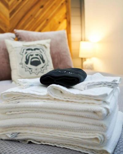a pile of towels on a bed with a pillow at UGA Penthouse Downtown Athens Walk To Stadium in Athens